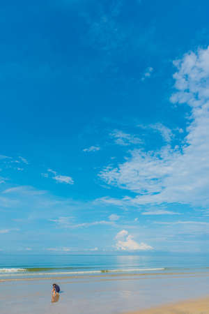 minimalist style image of people at the sea on day time for background usage.(vertical)の写真素材
