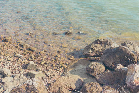 vintage tone image of rock on seashore day time for background.