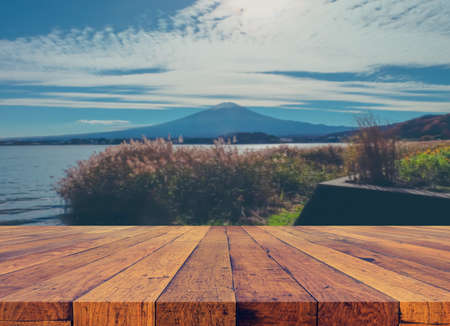 wood table and blur image of "fuji" mountain in japan for background usage .の写真素材