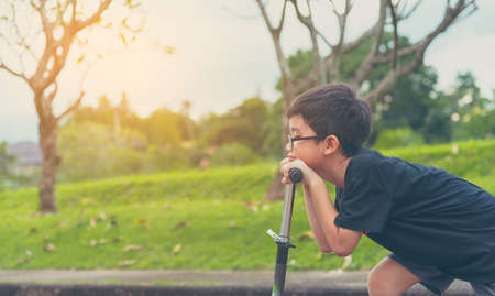 vintage tone image of Asian boy playing scooter on street.の写真素材