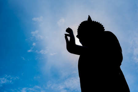 silhouette image of Buddha statue in Wat Phra That Doi Kham temple, Chiang Mai Thailand.の写真素材