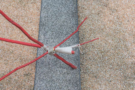 image of rope and wood forming the Tripod Lashing to twists and tightens together with rope knot in...