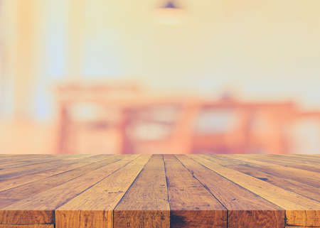 image of selective focus on surface of wood table and blur empty table in restaurant for background usage .の写真素材