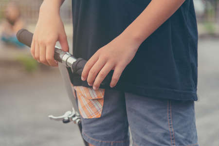 vintage tone image of Asian boy playing scooter on street.の写真素材