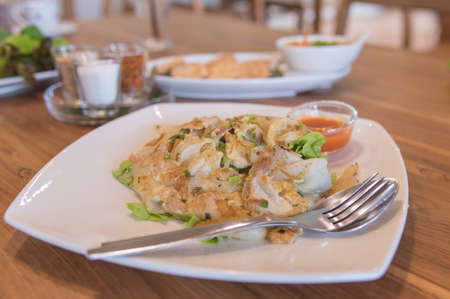 image of "Kuay Taew Kua Kai"  Thai style fried noodle with egg and chicken on wood table .の写真素材