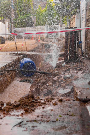 Image of tap water fountain leaking from pipeline after poor street construction and fix ground basement.の写真素材