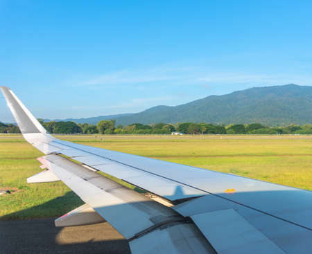 Image of view from plane window to see wing and blue sky for background.の写真素材