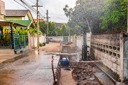 image of tap water fountain leaking from pipeline after poor street construction and fix ground basement.の写真素材