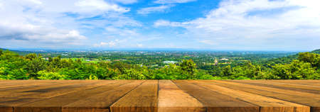 Image of wood table with hills and city in background.の写真素材