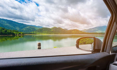 image of wing mirror to see lake and mountain beside on day time for background.の写真素材