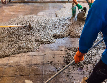 image of worker pouring concrete on the ground in the construction area.の写真素材