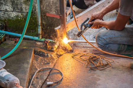 image of welder man fix the door with weld machine to see fire spark on steel rod.