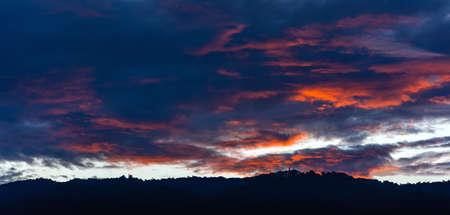 silhouette shot image of mountain and sunset sky with twilight light on clouds in background.の写真素材