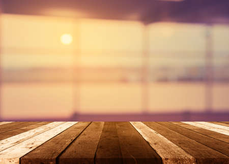 Wood table and blurred empty hallway in airport for background usage . (vintage tone)の写真素材