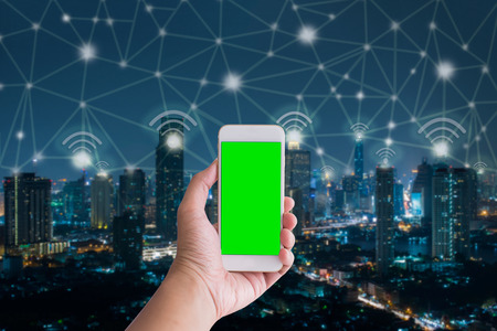 Handholding smartphone with city and connection line,network and technology conceptの写真素材