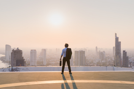 Businessman is looking at city on rooftopの写真素材