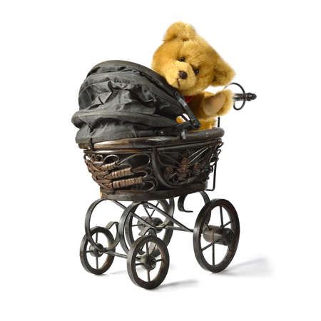 Soft fluffy teddy bear looking back and waving while sitting in a vintage style pram/stroller. Copy...