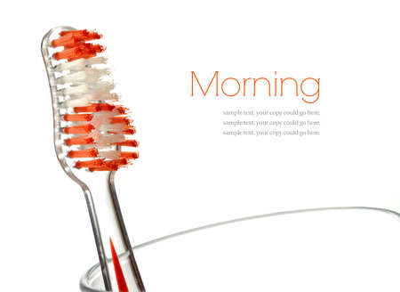 Macro of orange toothbrush head and bristles against white background. Copy space.