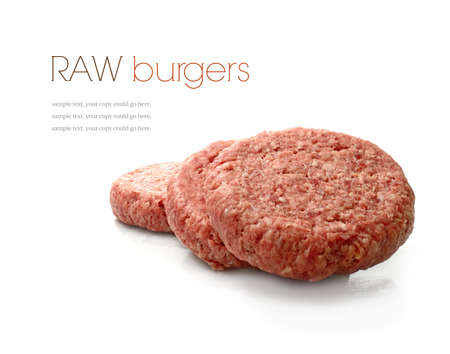 Raw uncooked beef burgers stacked against a white background with soft shadows. Copy space.の写真素材