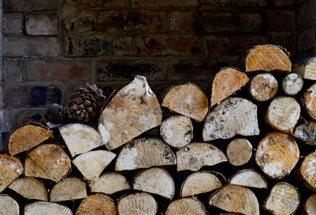 Rustic logs stacked in a holiday cottage open fire place in natural winter light. Copy space.