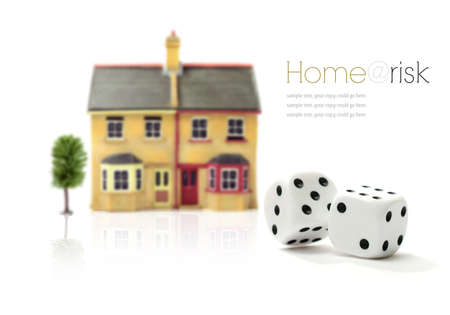 Investment risk concept stock photograph. Rolling dice and property against a white background. Copy...