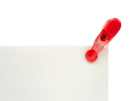 Macro of plastic paper clip positioned on slightly off-white card for your own message. Photographed against a white background. Copy space.の写真素材