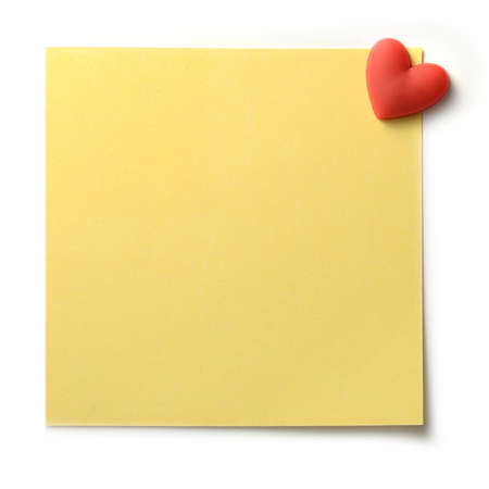 Studio macro of textured yellow post note pinned to a white background with a red heart shaped pin. Copy space.の写真素材