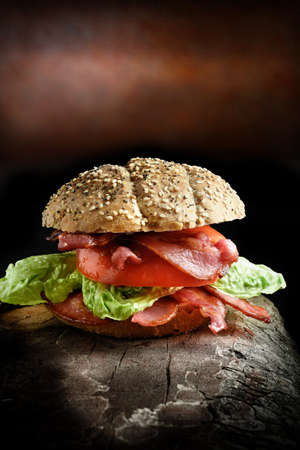 Bacon, lettuce and tomato meal, the Ultimate BLT. The perfect image for your restaurant or bistro menu designs. Shot in creative lighting in a rustic setting against a dark background. Copy space.の写真素材