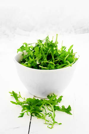 Fresh rocket salad leaf salad against a white, light, background. Concept image for healthy eating. Copy space.の写真素材