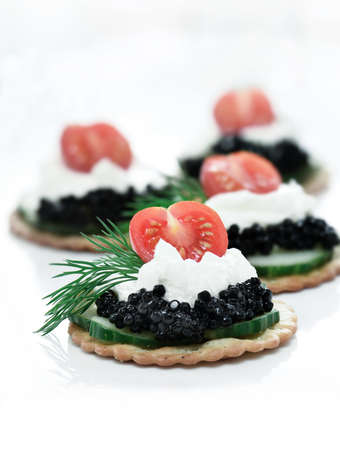 Delicious cream cheese, cucumber and caviar canapes against white. Copy space.の写真素材
