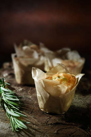 Italian cheese and onion mini souflettes with rosemary herb against a rustic dark background. Generous accommodation for copy space.の写真素材