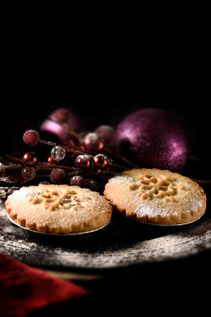 Festive mince pies against a dark background. the perfect image for your Christmas or Thanksgiving dessert menu cover design. Generous accommodation for copy space. Selective focus.の写真素材