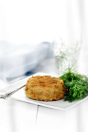 Classic cod fish cake with dill herb. Shot against a white background with generous accommodation...