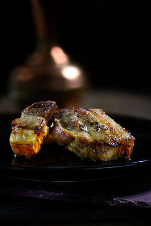 Roasted pork bellies shot in creative lighting against a dark background with generous accommodation for copy space.の写真素材