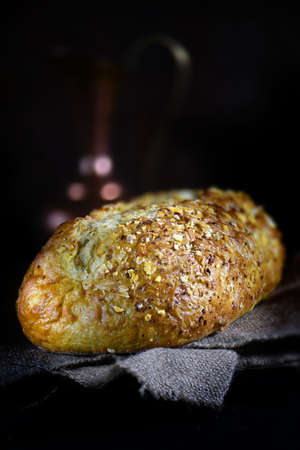 Freshly baked cornbread loaf set against a dark background with selective focus and creative...