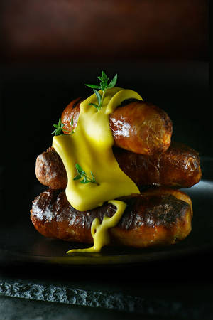 A real hotdog. Stacked grilled pork sausages smothered with English mustard. Concept food art image for bistro or restaurant menu cover art. Generous accommodation for copy space.の写真素材