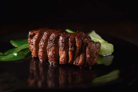 Wild Boar Fillet steak in iron skillet with Pak Choi. Selective focus and copy space. The perfect image for your bistro menu cover art.の写真素材