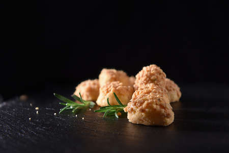 Goats Cheese and Rosemary biscuit nibbles shot against a black background with accommodation for...