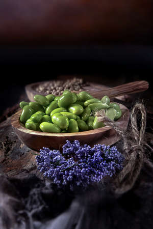 Bowl of organic edamame soybeans on dark rustic wooden platform with a rustic background with generous accommodation for copy space. Healthy vegetarian food.の写真素材