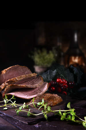 Sliced prime roast beef ready for serving shot against a festive and dark background with copy space.の写真素材