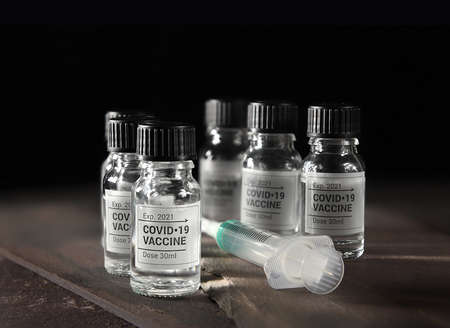 Creative concept image depicting the 2020 Covid-19 pandemic virus and the vaccine. Image can be modified to be both landscape and portrait orientation. Copy space.の写真素材