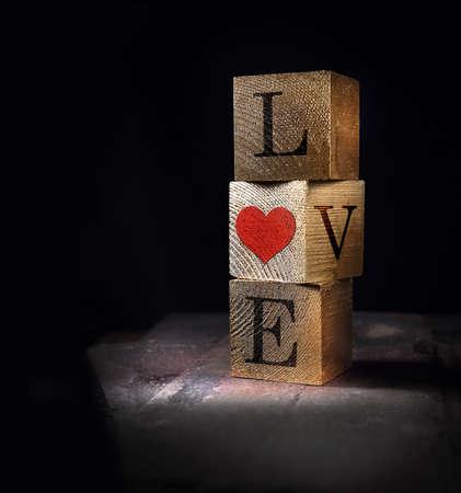 Creatively lit stacked cube squares of real wood with Valentines message of Love, concept image. Generous accommodation for copy space.の写真素材