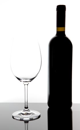 red wine glass and a wine bottle on table with white backgroundの写真素材