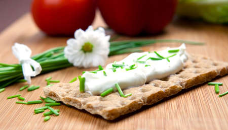crispbread with curd and chives on wooden boardの写真素材