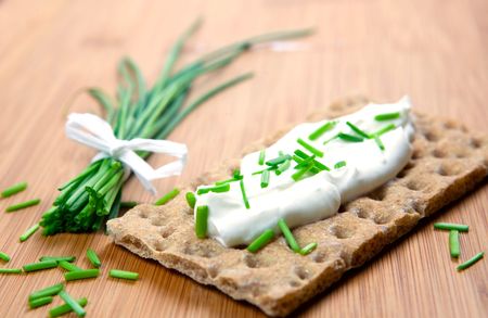 crispbread with curd and chives on boardの写真素材