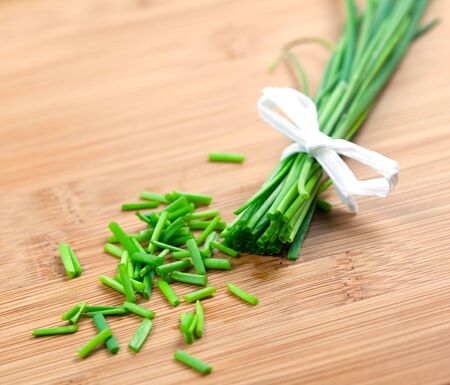 sliced chives on wooden boardの写真素材