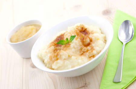 rice pudding and apple puree on table with spoonの写真素材