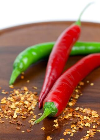 red and green chili pepper on wooden boardの写真素材