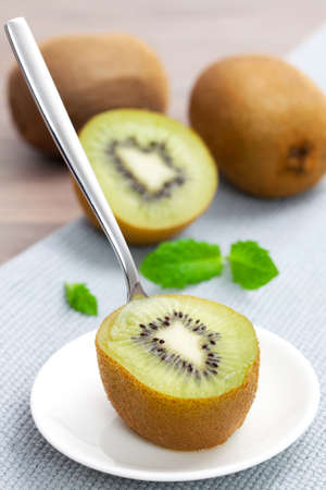 a half kiwi fruit with spoonの写真素材