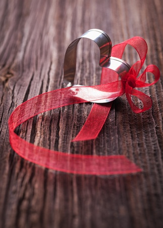 heart with red bow on wooden backgroundの写真素材